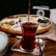 Pouring black tea into a glass, showcasing the rich color, highlighting the Health Benefits of Black Tea like improved heart health.