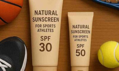 Two tubes of natural sunscreen for sports athletes with SPF 30 and 50, surrounded by tennis gear and a basketball.